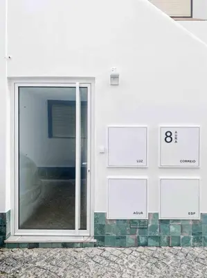a white wall with signs on the side of a building at Front Sea Apartment Albufeira in Albufeira