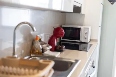 a kitchen counter with a sink and a microwave at Mercado Apartments in Faro