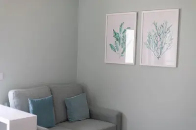 a living room with a couch and two pictures on the wall at Mercado Apartments in Faro