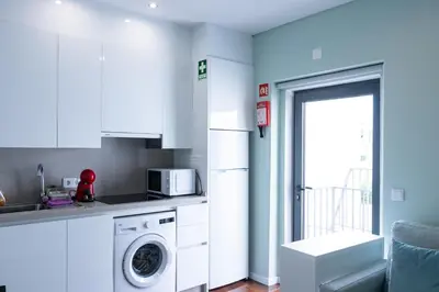 a kitchen with a washing machine and a microwave at Mercado Apartments in Faro