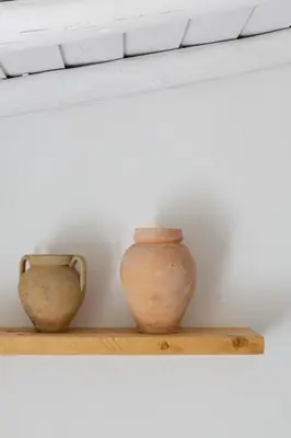two vases sitting on a shelf next to a wall at Âmago Guesthouse in Santa Bárbara de Nexe