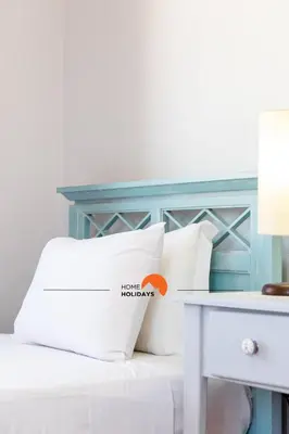 a bed with white pillows next to a table at #185 V3 Laranjeiras by Home Holidays in Albufeira