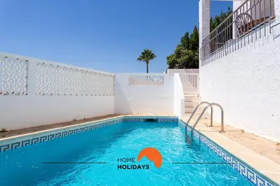 a swimming pool with a sign that says home holidays at #185 V3 Laranjeiras by Home Holidays in Albufeira
