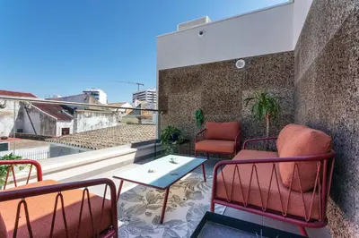 a patio with two chairs and a table on a balcony at Diamond Downtown Center in Faro