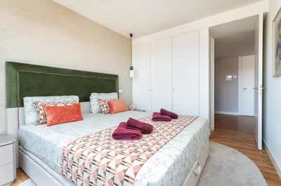a bedroom with a large bed with red pillows on it at Diamond Downtown Center in Faro