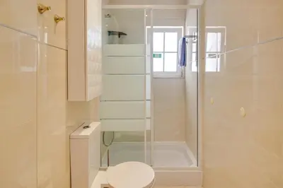 a bathroom with a toilet and a glass shower at Private Deluxe 3BD Villa Pool Wi-Fi AC BBQ in Albufeira
