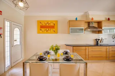 a kitchen with a glass table and chairs at Private Deluxe 3BD Villa Pool Wi-Fi AC BBQ in Albufeira