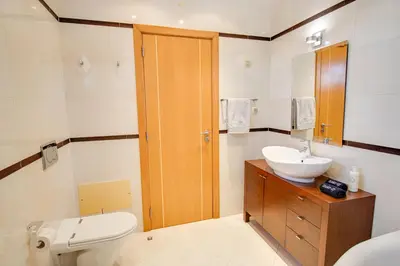 a bathroom with a sink and a toilet and a mirror at Private Deluxe 3BD Villa Pool Wi-Fi AC BBQ in Albufeira