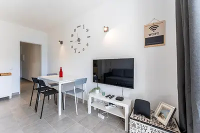 a dining room with a white table and a tv at Modern 2 BDR Flat W/Balcony and Pool by LovelyStay in Albufeira