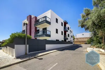 a white building on the side of a street at Palm Tree - Dream Lodging in Albufeira