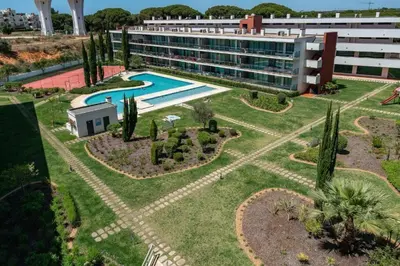 a resort with a swimming pool and a building at Residence Golf-Vilamoura! in Quarteira