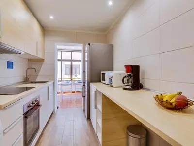 a kitchen with a counter with a bowl of fruit on it at AL - Apartamento Moural in Quarteira