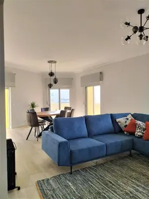 a blue couch in a living room with a table at T2 Requinte e Vista Mar 4 pax in Quarteira
