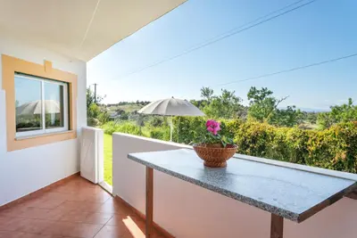 a table and chairs with an umbrella on the grass at BnB Homes Large fully equipped Apartment with 2 bedrooms, swimming pool & patio in Albufeira