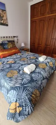 a bedroom with a bed with a blue and yellow blanket at Vilamoura-Quarteira Beaches Apt with pool and sea view in Quarteira