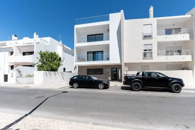 two cars parked in front of a building at Stunning 3 BDR Flat W/ Rooftop Pool by LovelyStay in Albufeira