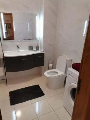 a bathroom with a toilet and a sink and a washing machine at Apartamento Turistico Silva in Albufeira