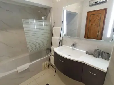 a bathroom with a sink and a mirror and a tub at Apartamento Turistico Silva in Albufeira
