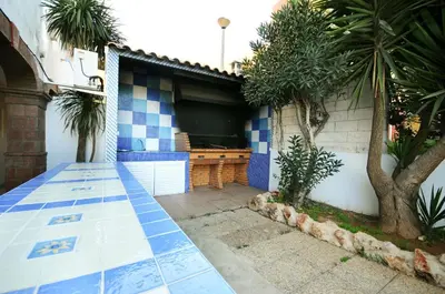 a house with a blue and white tile floor and a pool at Apartamento Turistico Silva in Albufeira