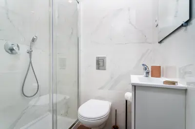 a white bathroom with a shower and a toilet at Privilege Casa dos Capuchinhos, in the heart of Faro in Faro