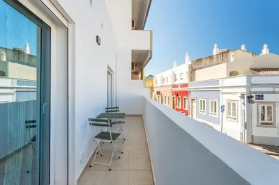 a balcony with a chair on the side of a building at Privilege Casa dos Capuchinhos, in the heart of Faro in Faro