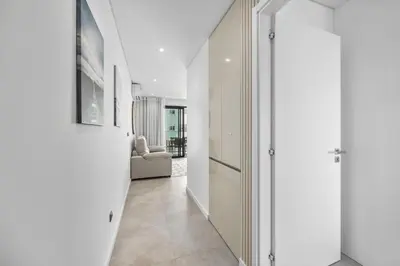 a hallway with white cabinets and a living room at Terracos de Quarteira II Navy by Real Properties in Quarteira