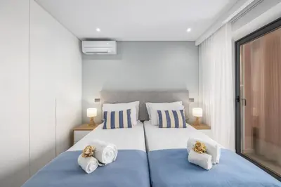 a bedroom with a large bed with two pillows at Terracos de Quarteira II Navy by Real Properties in Quarteira