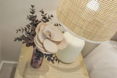 a vase with flowers on a table with a lamp at Terracos de Quarteira II Purple by Real Properties in Quarteira
