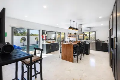 a kitchen with black cabinets and a table and chairs at Casa Chameleon in Almancil