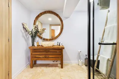 a bathroom with a mirror and a wooden dresser at Casa Chameleon in Almancil