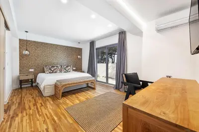 a bedroom with a bed and a desk and a window at Casa Chameleon in Almancil