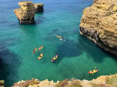 a man jumping off two large rocks into the water at Orange Terrace Hostel in Albufeira