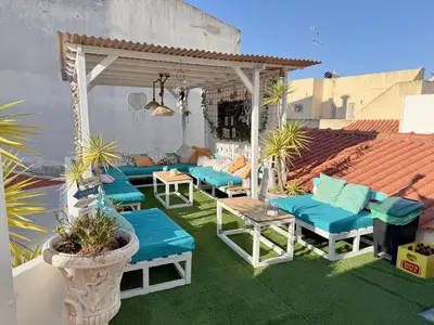a patio with blue cushioned chairs and a gazebo at Orange Terrace Hostel in Albufeira
