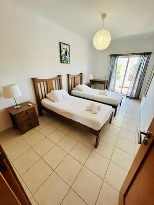 a bedroom with two beds and a table and a lamp at Ferreiras Villa in Albufeira
