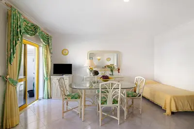 a bedroom with a table and chairs and a bed at Vila Mar Azul in Quarteira