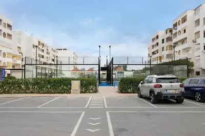 a parking lot with cars parked in front of buildings at Vila Mar Azul in Quarteira