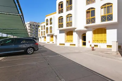 a car parked on a street next to a white building at Vila Mar Azul in Quarteira
