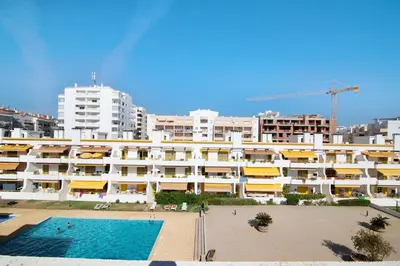a large building with a swimming pool in front of it at Vila Mar Azul in Quarteira