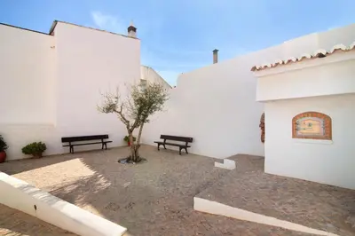 a courtyard with two benches and a tree at Casa de Benafim 1 in Benafim