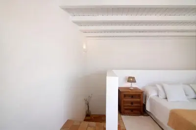 a white bedroom with a bed and a nightstand at Casa de Benafim 51 in Benafim