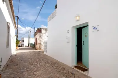 an alley with a white building with a green door at Casa de Benafim 51 in Benafim