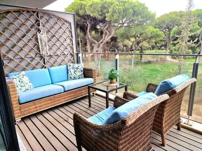 a patio with wicker chairs and a couch on a deck at Spacious Residence Golf apartment - Vilamoura in Quarteira