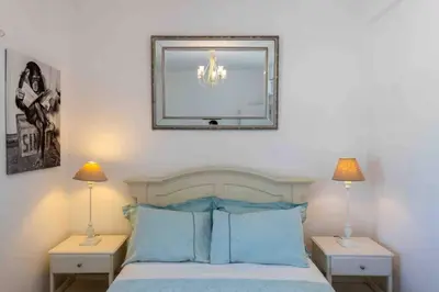 a bedroom with a bed with blue pillows and a mirror at Casa Emella Luxury Villa Albufeira in Albufeira