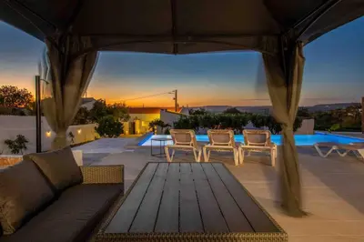 a patio with a couch and chairs and a table at Casa Emella Luxury Villa Albufeira in Albufeira