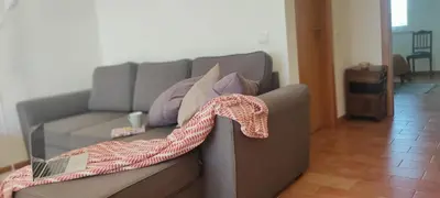 a couch in a room with a red and white blanket at Solar da Cotovia in Albufeira