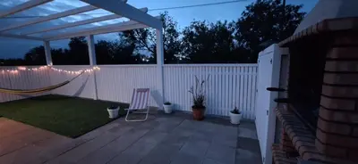 a patio with a white fence and a string of lights at Solar da Cotovia in Albufeira