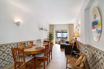 a living room with a table and chairs and a couch at Blue wave escape apartment -T1 perto da praia com varanda in Albufeira