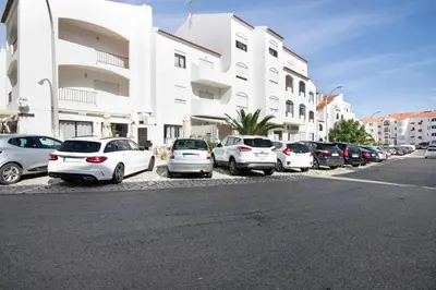 a row of cars parked in a parking lot next to a building at Blue wave escape apartment -T1 perto da praia com varanda in Albufeira