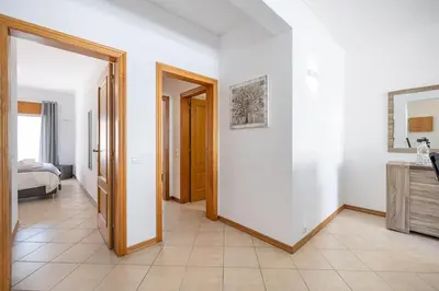 a hallway with white walls and a bedroom with a bed at Sea-Front 1' Min! - Apartment with AC & WiFi in Quarteira