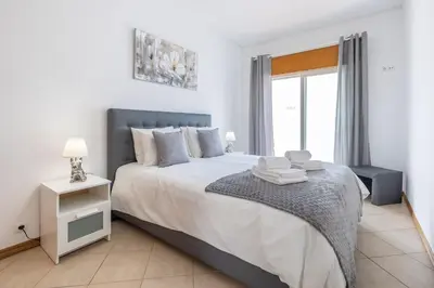 a bedroom with a large bed and a window at Sea-Front 1' Min! - Apartment with AC & WiFi in Quarteira
